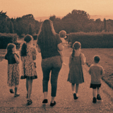 Vintage-style photo of a homeschool family walking outdoors, used as branding for Katelynn Potter's Christian faith-based printable shop.